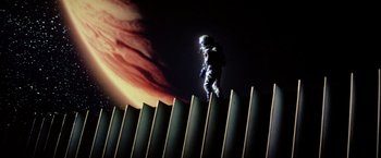 Movie still from “Outland” (1981), directed by Peter Hyams – A man standing on top of a metal fence; Extreme Wide shot, Low angle