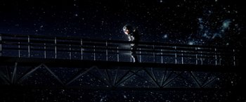 Movie still from “Outland” (1981), directed by Peter Hyams – A person standing on a bridge at night; Wide shot, Overhead angle
