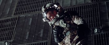 Movie still from “Outland” (1981), directed by Peter Hyams – A man wearing a helmet and a suit; Medium shot, Low angle