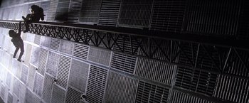 Movie still from “Outland” (1981), directed by Peter Hyams – A dark room with a lot of ventilation grates on the wall; Extreme Wide shot, Low angle