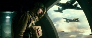 Movie still from “Overlord” (2018), directed by Julius Avery – A man looking out the window of an airplane; Medium shot, Low angle