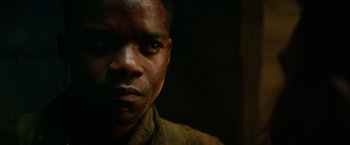 Movie still from “Overlord” (2018), directed by Julius Avery – A man's face in a dark room; Close Up shot, Low angle