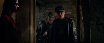 Movie still from “Overlord” (2018), directed by Julius Avery – Two men in military garb standing next to each other; Medium shot, Low angle