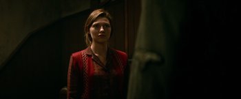 Movie still from “Overlord” (2018), directed by Julius Avery – A woman standing in front of a mirror in a room; Medium shot, Over the shoulder angle