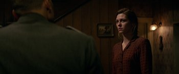 Movie still from “Overlord” (2018), directed by Julius Avery – A woman standing in front of a man in front of a mirror; Medium shot, Over the shoulder angle