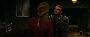 Movie still from “Overlord” (2018), directed by Julius Avery – A man in uniform looking at a woman in a red dress; Medium shot, Over the shoulder angle