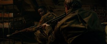 Movie still from “Overlord” (2018), directed by Julius Avery – Two men in military fatigues are holding guns; Medium shot, High angle