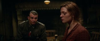 Movie still from “Overlord” (2018), directed by Julius Avery – A man and a woman sitting at a wooden table; Medium shot, Over the shoulder angle