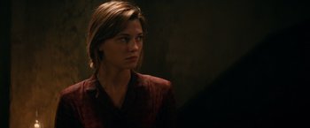 Movie still from “Overlord” (2018), directed by Julius Avery – A young woman in a red shirt looking to her left; Close Up shot, Over the shoulder angle