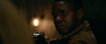 Movie still from “Overlord” (2018), directed by Julius Avery – A person holding a gun in his hand; Close Up shot, Over the shoulder angle