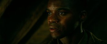 Movie still from “Overlord” (2018), directed by Julius Avery – A man's face in the dark; Close Up shot, Low angle