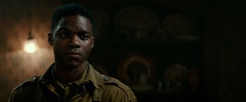 Movie still from “Overlord” (2018), directed by Julius Avery – A young man in a military uniform stands in front of a wall; Close Up shot, Low angle
