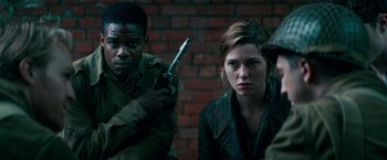Movie still from “Overlord” (2018), directed by Julius Avery – A man holding a gun next to a woman with a gun; Medium shot, Over the shoulder angle