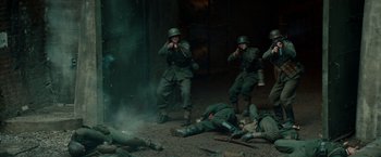 Movie still from “Overlord” (2018), directed by Julius Avery – A group of men in uniforms are standing in the middle of a war scene; Wide shot, High angle