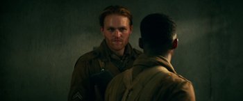 Movie still from “Overlord” (2018), directed by Julius Avery – A man in a military uniform talking to another man; Close Up shot, Over the shoulder angle
