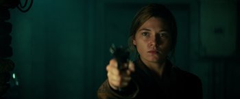 Movie still from “Overlord” (2018), directed by Julius Avery – A woman is holding a gun in a dark room; Close Up shot, Over the shoulder angle