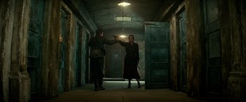 Movie still from “Overlord” (2018), directed by Julius Avery – A woman and a man are holding hands in a hallway; Wide shot, Low angle