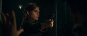 Movie still from “Overlord” (2018), directed by Julius Avery – A woman holding a gun in a dark room; Close Up shot, Low angle
