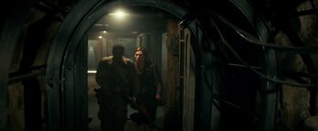 Movie still from “Overlord” (2018), directed by Julius Avery – A man and a woman are walking through a tunnel; Wide shot, High angle