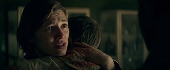 Movie still from “Overlord” (2018), directed by Julius Avery – A woman holding a child in her arms and crying; Close Up shot, Over the shoulder angle