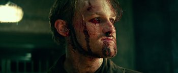 Movie still from “Overlord” (2018), directed by Julius Avery – A person with blood all over his face; Close Up shot, Low angle