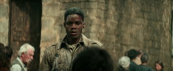 Movie still from “Overlord” (2018), directed by Julius Avery – A man with a bandage on his face; Close Up shot, Over the shoulder angle