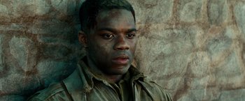 Movie still from “Overlord” (2018), directed by Julius Avery – A young man in a brown jacket is looking at the camera; Close Up shot, High angle