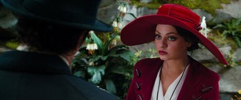 Movie still from “Oz the Great and Powerful” (2013), directed by Sam Raimi – A woman wearing a red hat and a red jacket; Close Up shot, Over the shoulder angle