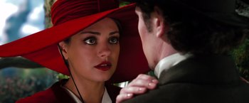 Movie still from “Oz the Great and Powerful” (2013), directed by Sam Raimi – A woman wearing a red hat looking at a man in a suit; Close Up shot, Over the shoulder angle