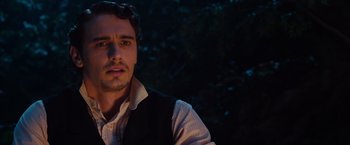 Movie still from “Oz the Great and Powerful” (2013), directed by Sam Raimi – A person wearing a shirt and vest; Close Up shot, Over the shoulder angle