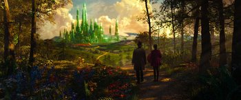 Movie still from “Oz the Great and Powerful” (2013), directed by Sam Raimi – Two people are walking on a path near a forest; Extreme Wide shot, High angle