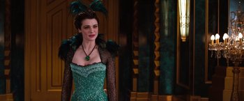 Movie still from “Oz the Great and Powerful” (2013), directed by Sam Raimi – A woman wearing a green dress and a green necklace; Medium shot, Over the shoulder angle