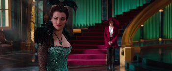 Movie still from “Oz the Great and Powerful” (2013), directed by Sam Raimi – A woman in a green dress standing next to another woman in a red suit; Medium shot, Over the shoulder angle