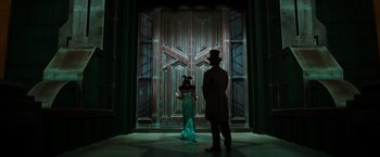 Movie still from “Oz the Great and Powerful” (2013), directed by Sam Raimi – A man and a woman standing in front of a door; Wide shot, Low angle