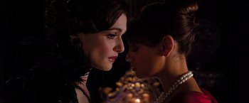 Movie still from “Oz the Great and Powerful” (2013), directed by Sam Raimi – Two women are looking at one another in a dark room; Close Up shot, Over the shoulder angle