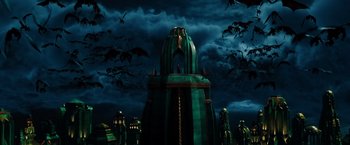 Movie still from “Oz the Great and Powerful” (2013), directed by Sam Raimi – A green and black building and some bats in the background; Extreme Wide shot, Low angle