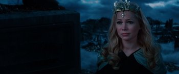 Movie still from “Oz the Great and Powerful” (2013), directed by Sam Raimi – A woman wearing a crown standing in front of a body of water at night; Close Up shot, Over the shoulder angle