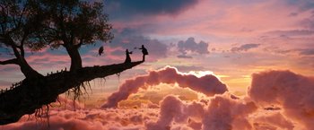 Movie still from “Oz the Great and Powerful” (2013), directed by Sam Raimi – Two people are sitting on a tree branch in the middle of the sky; Extreme Wide shot, Low angle