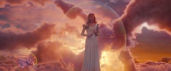 Movie still from “Oz the Great and Powerful” (2013), directed by Sam Raimi – A woman standing in front of a sunset; Wide shot, Low angle