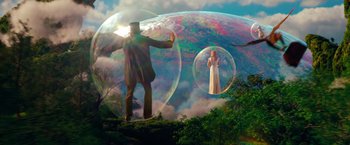 Movie still from “Oz the Great and Powerful” (2013), directed by Sam Raimi – A man and a woman are in a bubble in the middle of a forest; Wide shot, Low angle