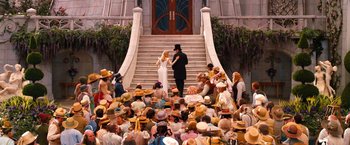 Movie still from “Oz the Great and Powerful” (2013), directed by Sam Raimi – A crowd of people sitting in front of a building; Wide shot, High angle