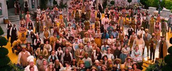 Movie still from “Oz the Great and Powerful” (2013), directed by Sam Raimi – A large group of people wearing hats and costumes; Wide shot, High angle