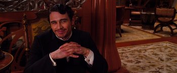 A man sitting in a chair with his hands clasped together