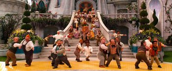 Movie still from “Oz the Great and Powerful” (2013), directed by Sam Raimi – A group of men are standing in front of a staircase; Wide shot, High angle