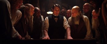 Movie still from “Oz the Great and Powerful” (2013), directed by Sam Raimi – A man standing in front of a group of people; Medium shot, Low angle