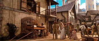 Movie still from “Oz the Great and Powerful” (2013), directed by Sam Raimi – A group of people standing next to each other near a wagon; Wide shot, Low angle
