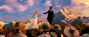 Movie still from “Oz the Great and Powerful” (2013), directed by Sam Raimi – A man and a woman are standing in front of a crowd; Wide shot, Low angle