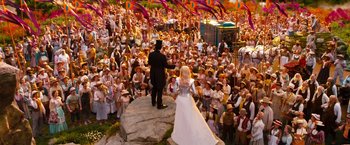 Movie still from “Oz the Great and Powerful” (2013), directed by Sam Raimi – A bride and groom are standing in front of a crowd of people; Extreme Wide shot, High angle