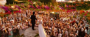 Movie still from “Oz the Great and Powerful” (2013), directed by Sam Raimi – A bride and groom are standing in front of a crowd of people; Wide shot, High angle