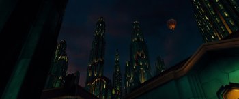 Movie still from “Oz the Great and Powerful” (2013), directed by Sam Raimi – A group of tall buildings lit up at night; Extreme Wide shot, Low angle